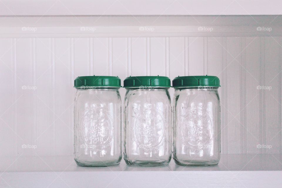 Green Color Story - mason jars with green lids on a white beadboard shelf