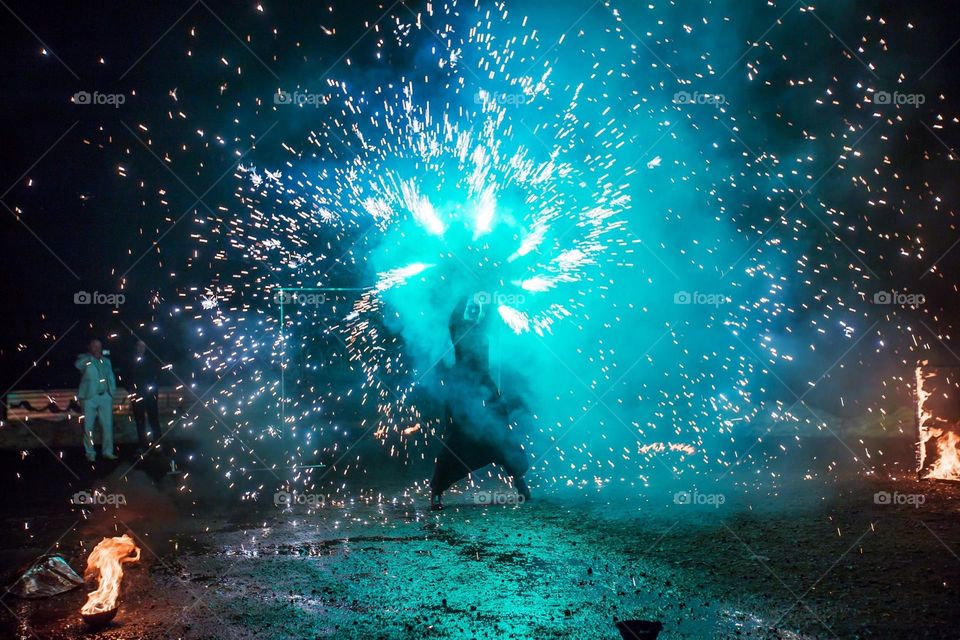 nighttime firework show using a variety of different colored lights, especially blue ones. A beautiful contrast between the dark season and the blue lights