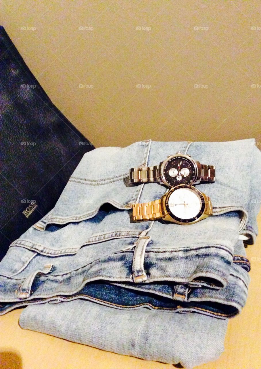 Wristwatches with denim on table
