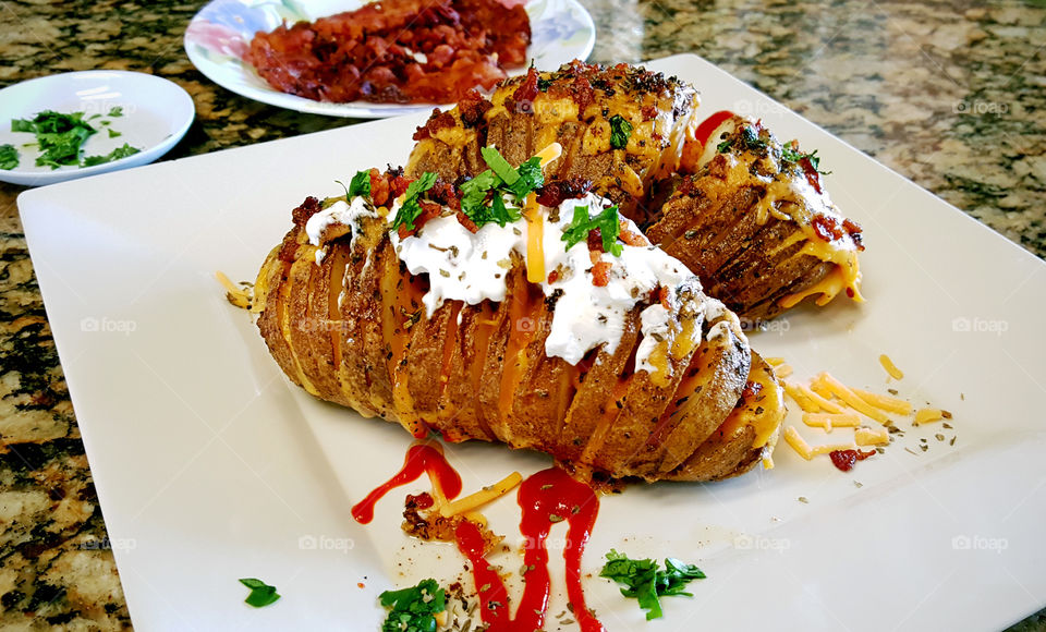 Food is served, homemade loaded hasselback potatoes, bacon and cheese on top