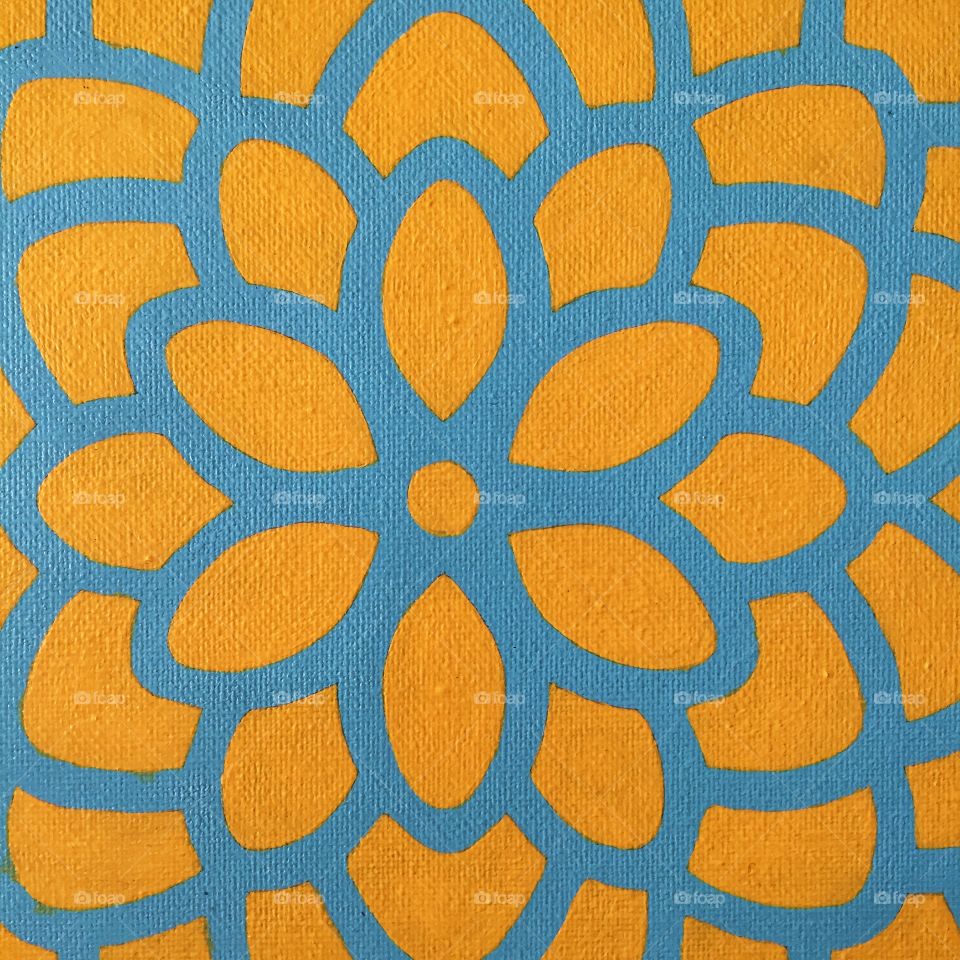 An abstract image of a yellow flower on a blue background. The flower has a small circle at the middle and is otherwise completely unrepresentational.