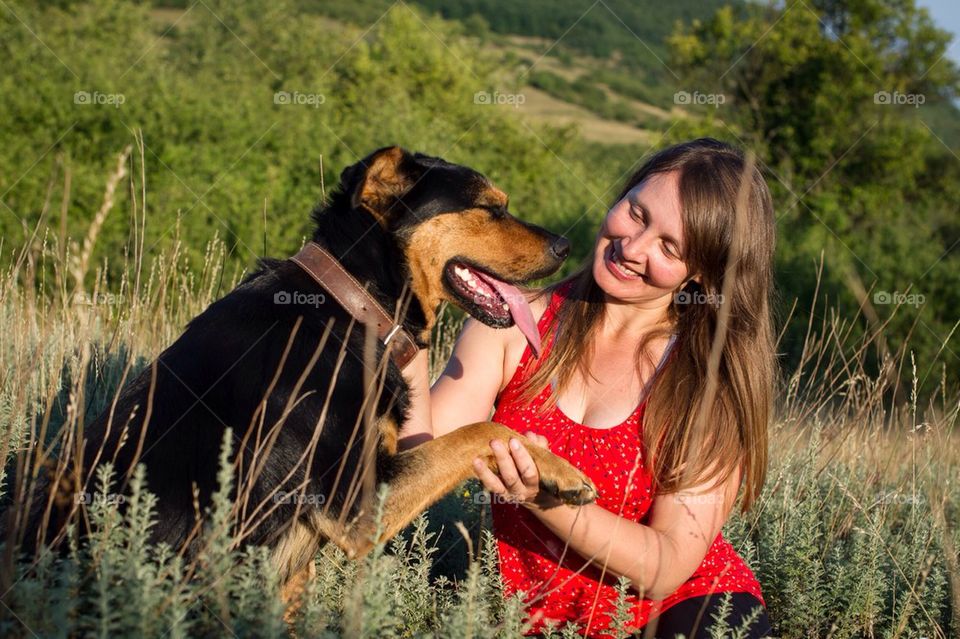 Girl with dog sitting down in the grass