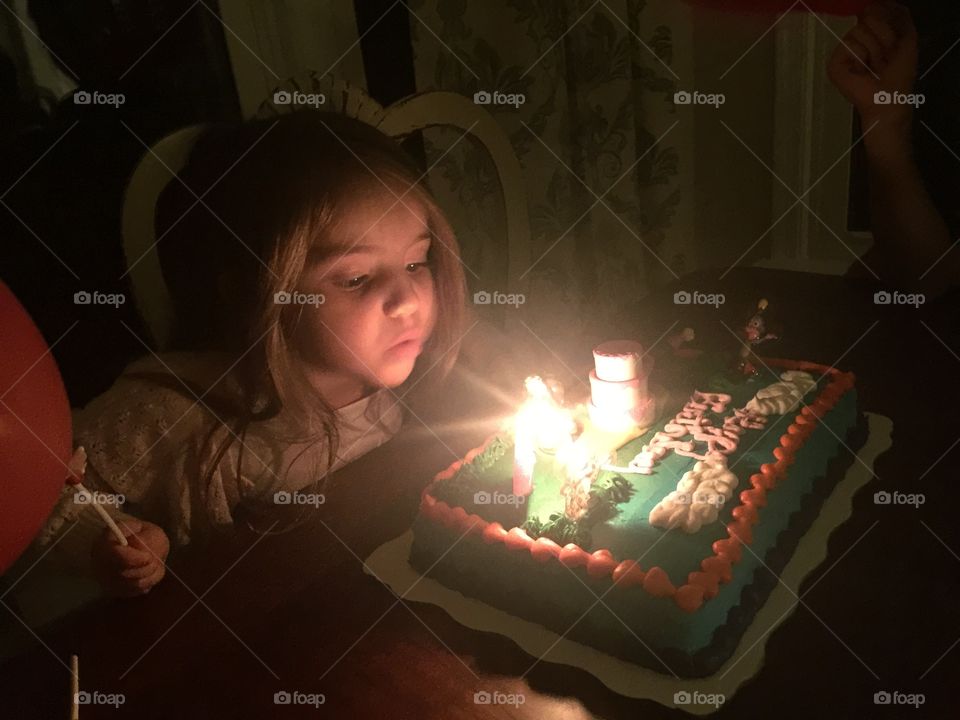 Girl blows out birthday candles 