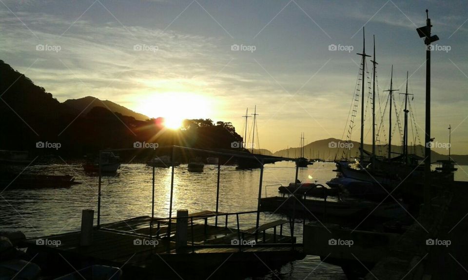 Sol nas nuvens a tarde, rio, paisagem, barcos, turismo.