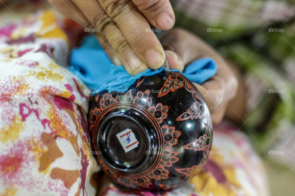 These expert hands of the lacquer crafts person belong to a strong woman 