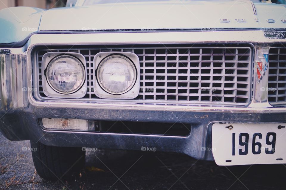 Picture of a vintage car that is almost grey, with the year 1969 shown on the licence plates. 