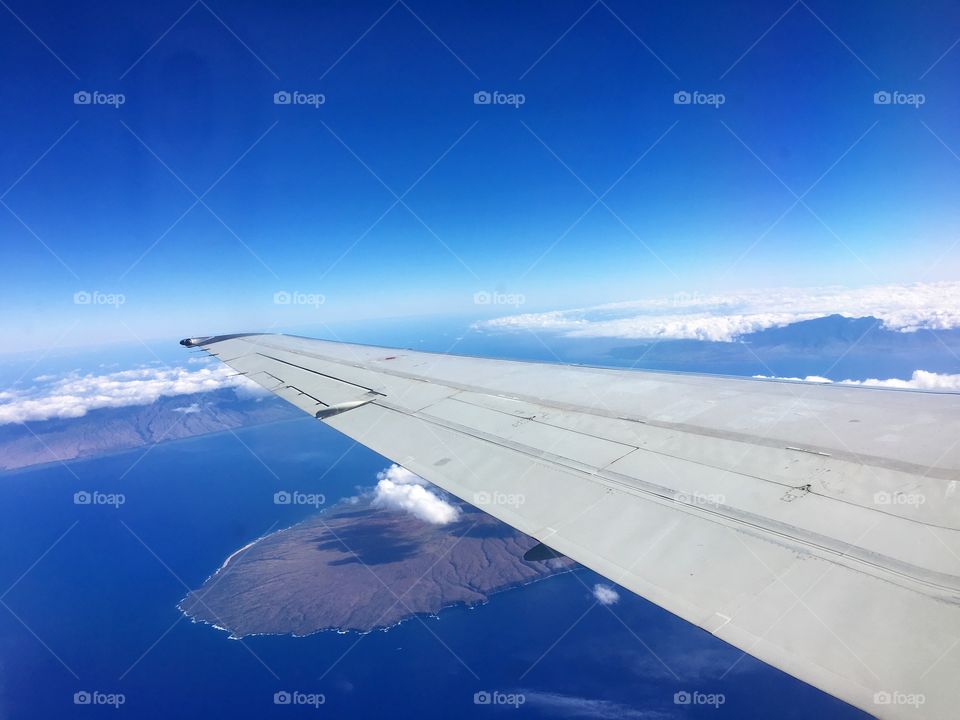 Aeroplane flying over ocean and island