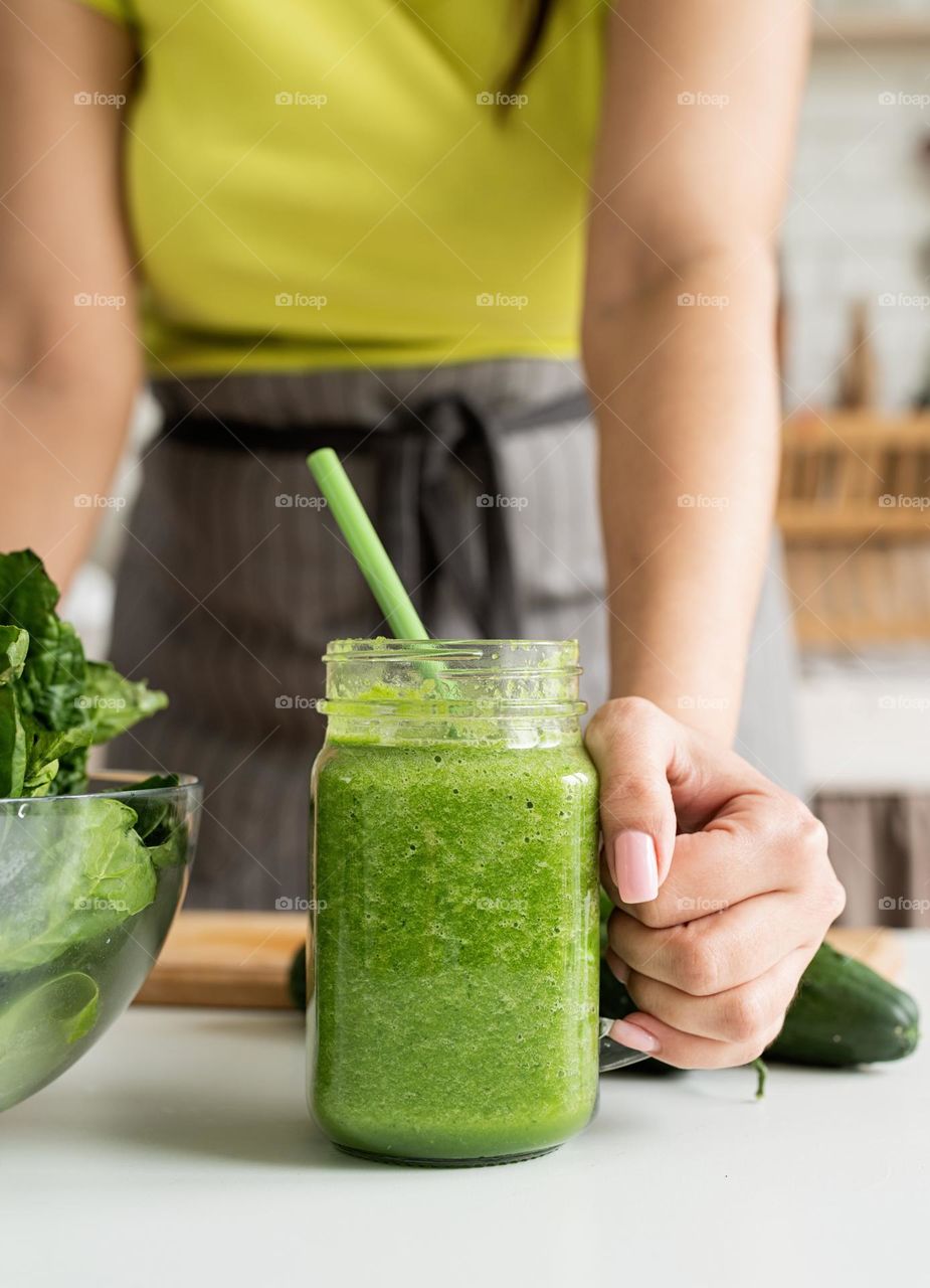 woman drinking green smoothie