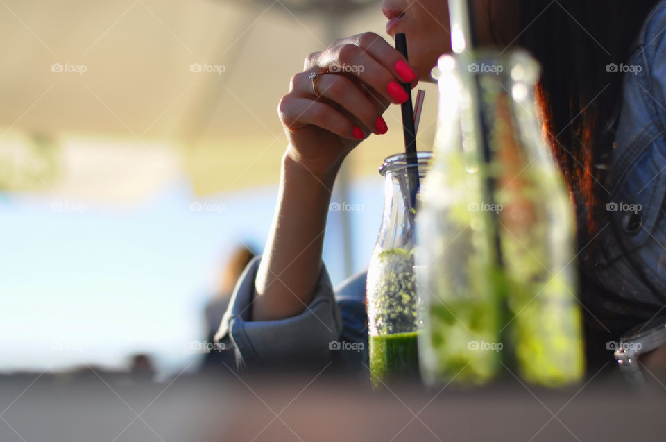 Woman drining mojito cocktail in pub 