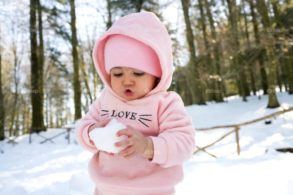 the amazement of a little girl in front of the snow