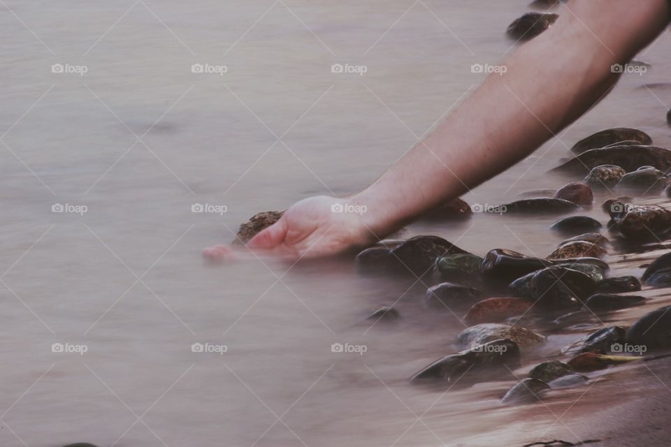 Person's hand in river