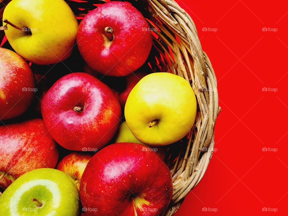 detail of fruit basket on red background photographed from above