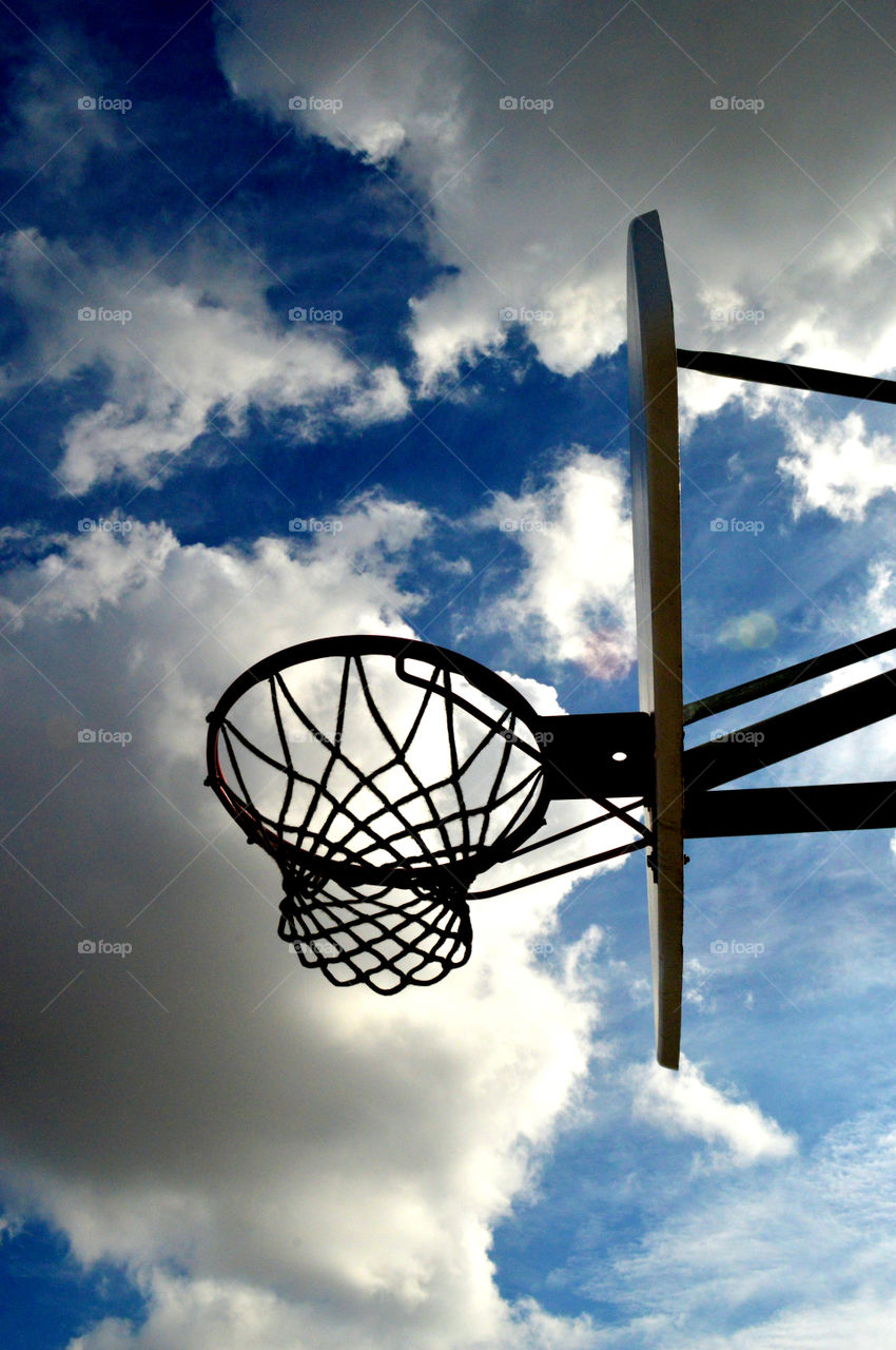 Basketball net. A basketball net sits in front of the blue sky.