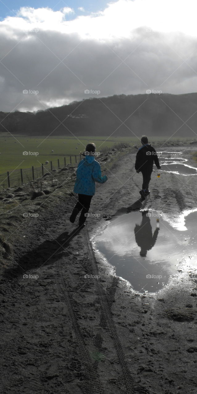 Kids skipping around puddles