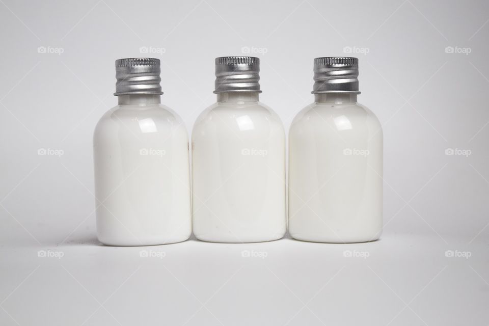 Small bottles filled with white cream.
