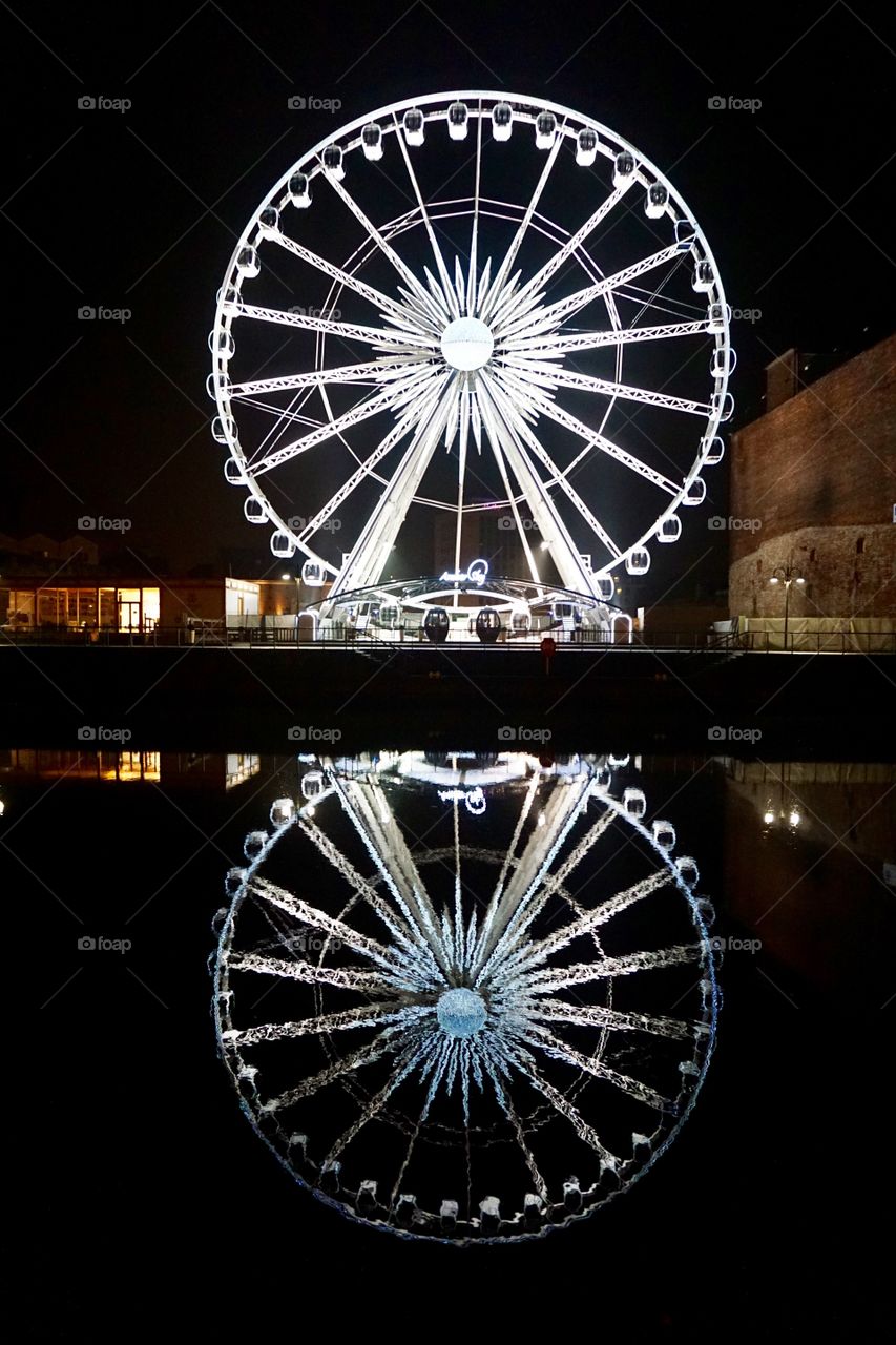 Night time in Gdańsk ... lit up Ferris wheel reflected in the water .. 