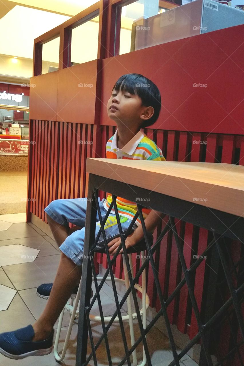 A boy waiting for his snack that he'd  been order at the restaurant