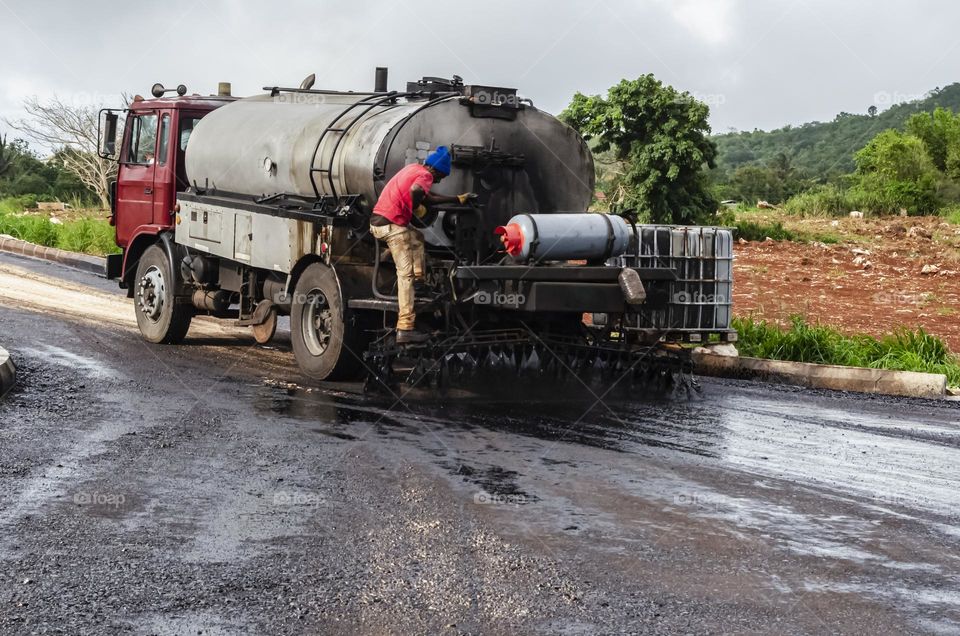 Spreading Oil On New Roadway