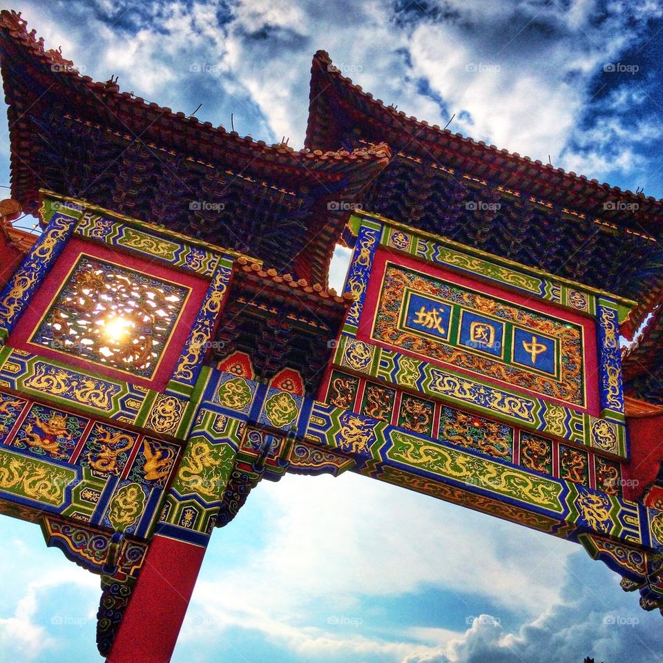 A Chinese arch glistens on front of the afternoon sun 