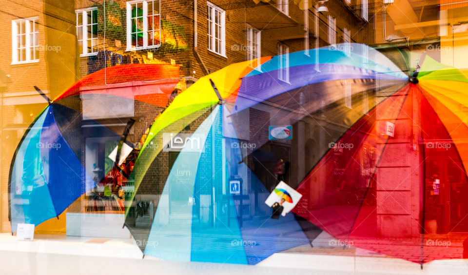 colourful umbrellas creating a beautiful reflection of the surrounding buildings and the street.