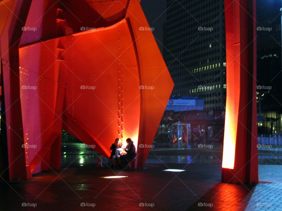 two girls talking under the red steel structure