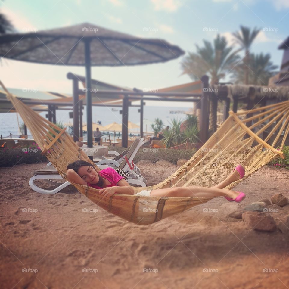 Woman resting in hammock at beach