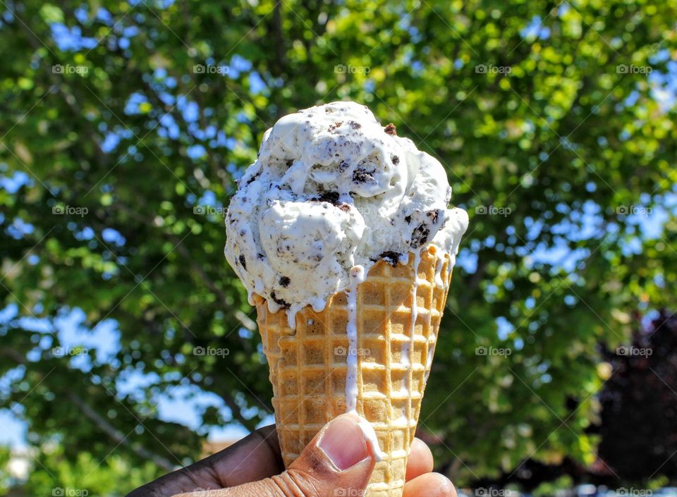 Person's hand holding ice cream cone
