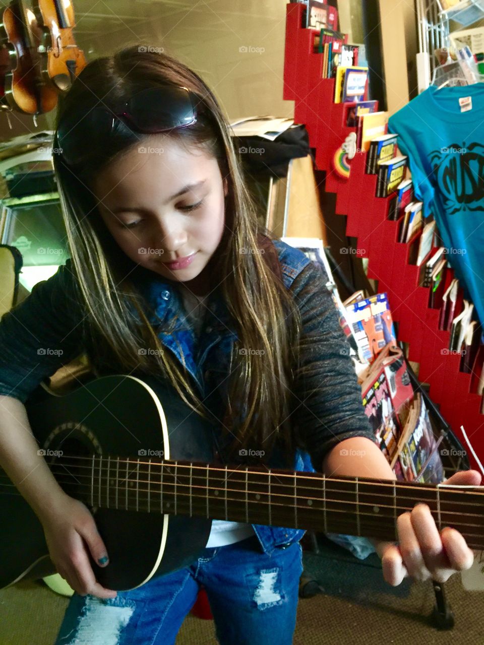 A Ten year old girl shopping for a new guitar 