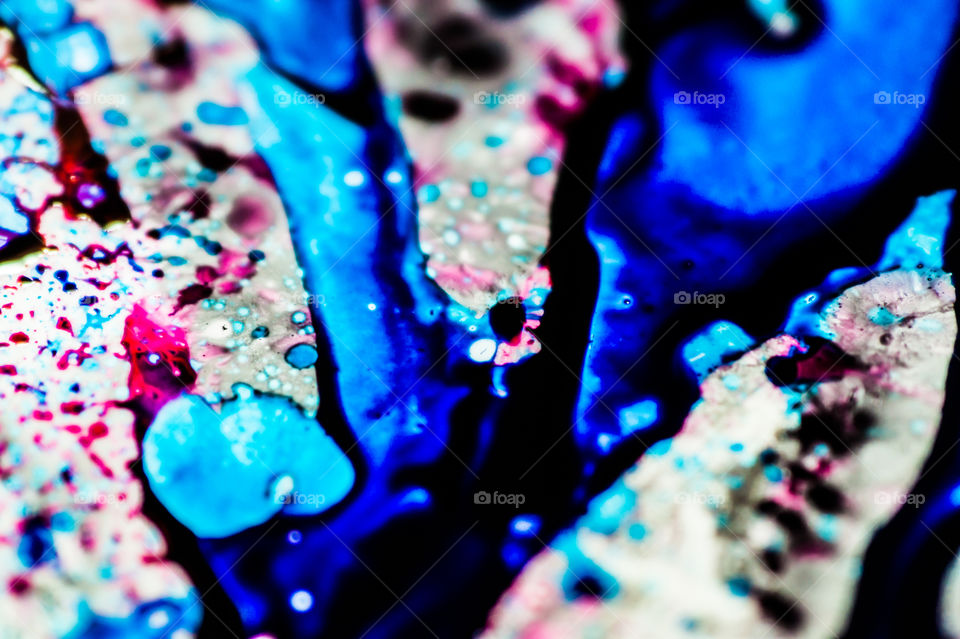 The ink to refill the printer cartridge was spilled onto the white washbasin and the paints blended into abstract drips and patterns.