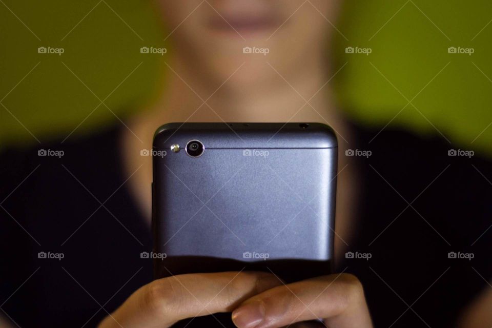 Watching mobile phone. Grey and blue.