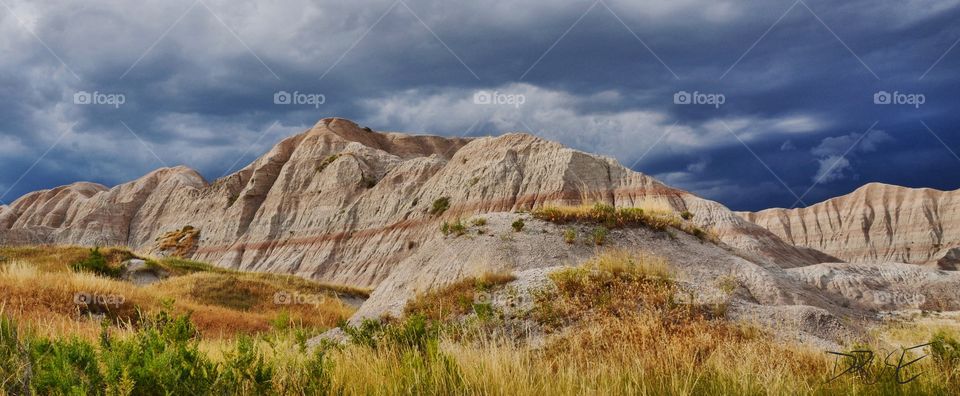 A storm rolling into the backcountry of Badlands National Park on a summer day. Ominous clouds and striking color.