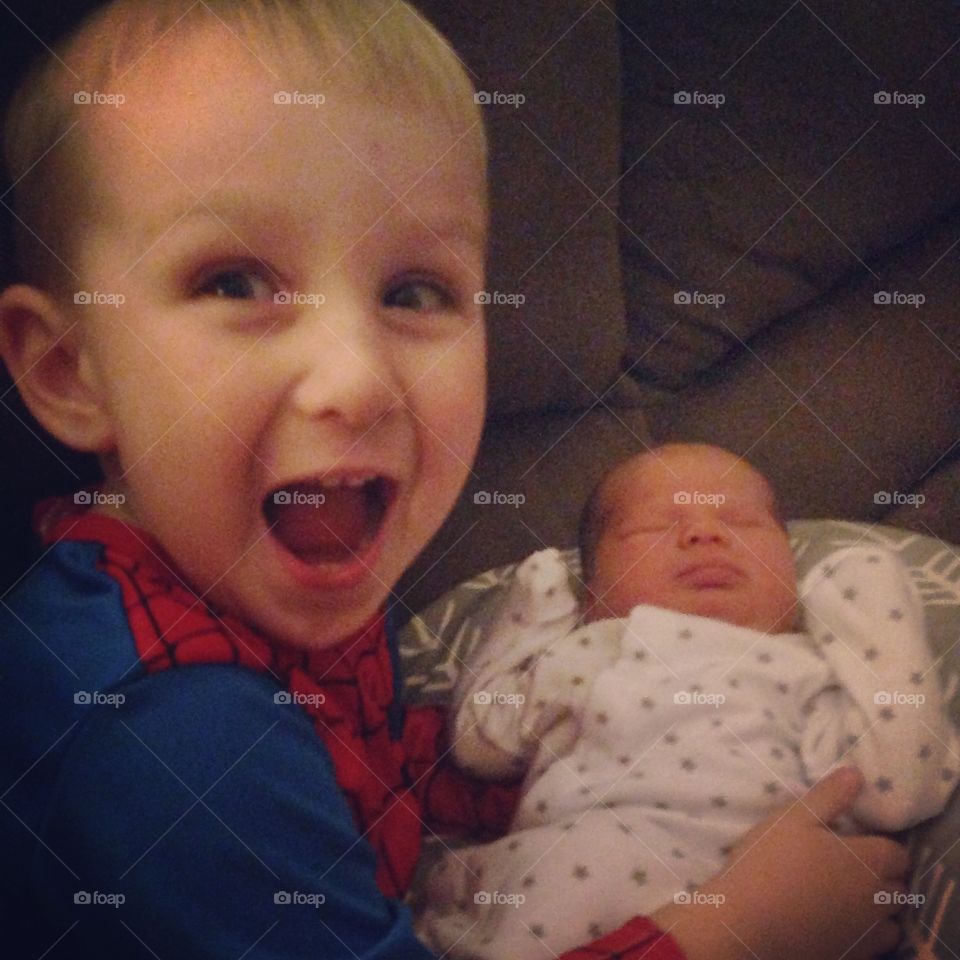 Close-up of a happy boy with newborn baby