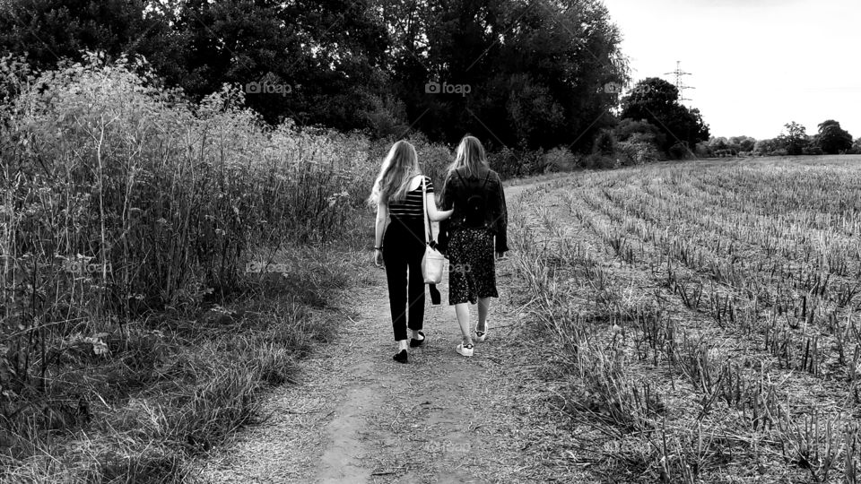 Girls walking down a field in black and white