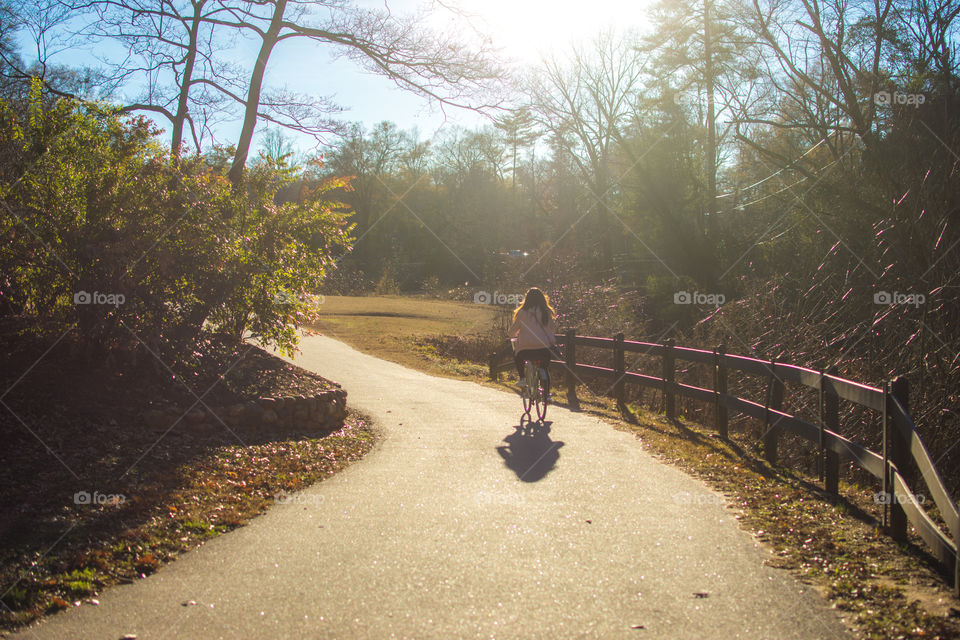 Girl biking down path park