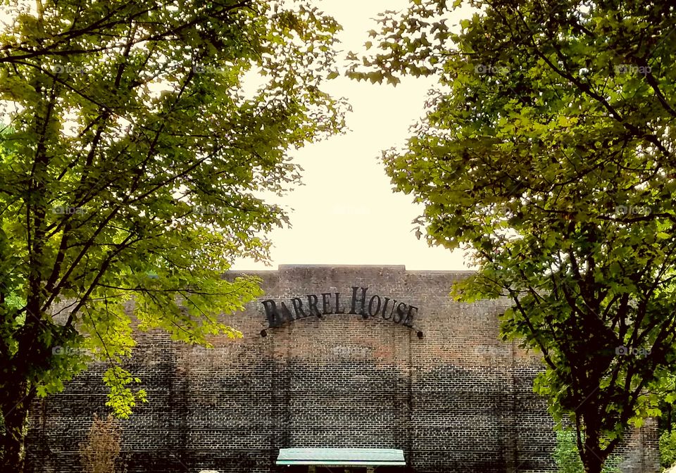 Brick Barrel House Brick Building flanked by leafy green trees