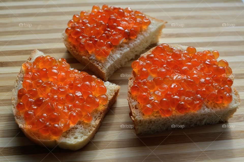 sandwiches with red caviar wood table background