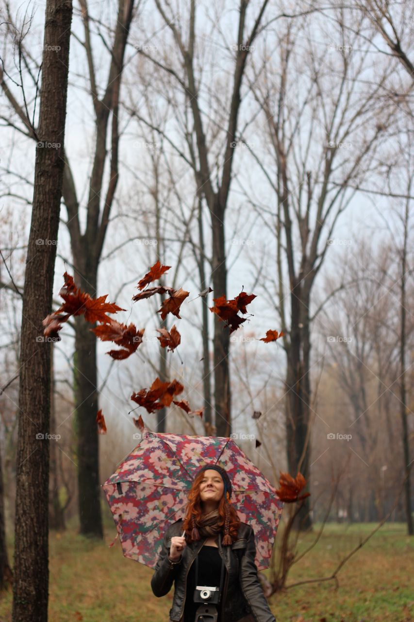 Young woman holding umbrella in autumn season