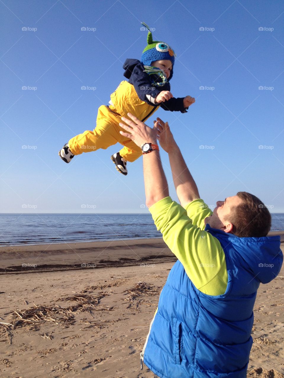 Man throwing his son in the air at beach