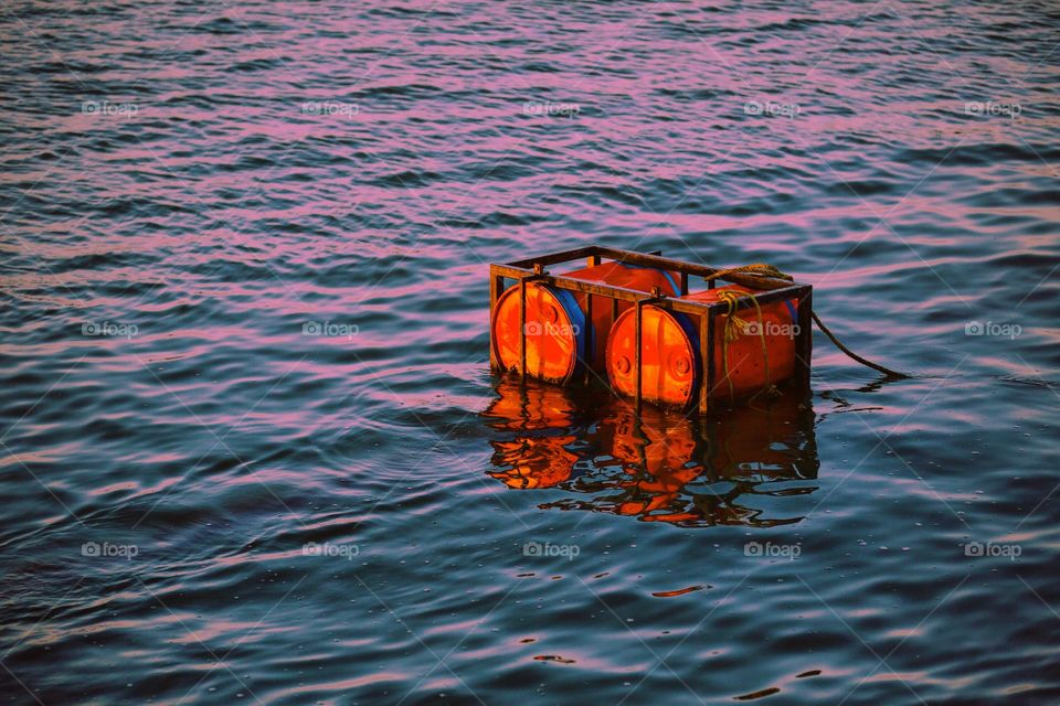 Gorgeous sunrise reflection on the ocean with red tubs