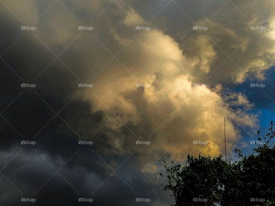 White clouds in the sky.  And dark clouds.  The sky is blue.  It is a very beautiful picture.