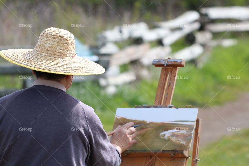 A painter strikes  his brush throughout his work on a sunny spring day