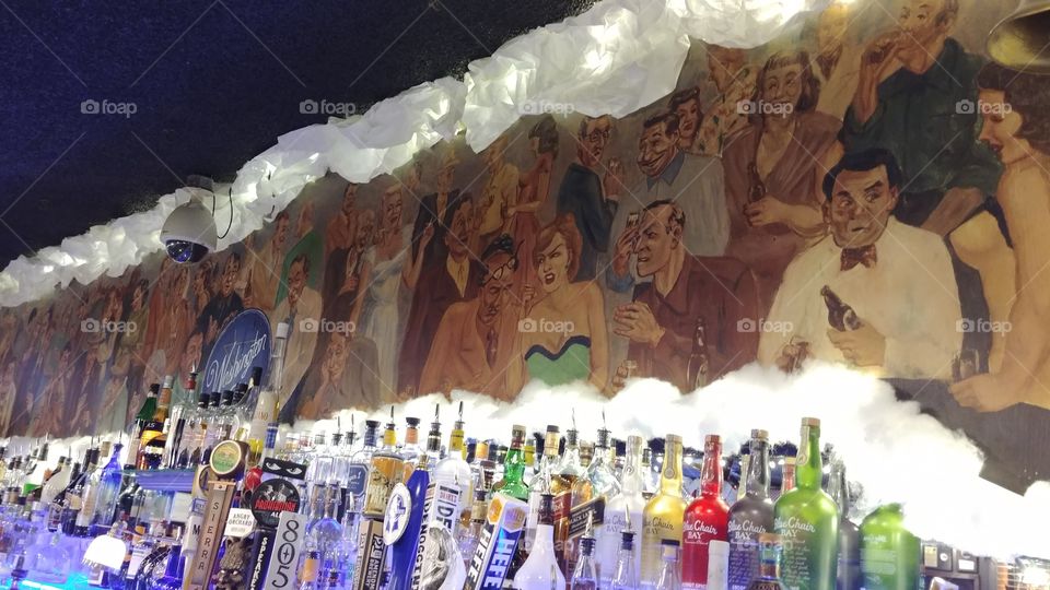 Mural behind the bar hard alcohol and beer taps in San leandro California at Washington club