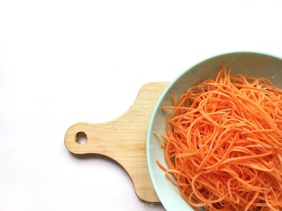 carrot salad in a plate on a wooden board.