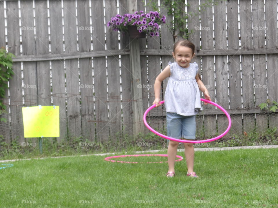 Stop! Hula Time. Young girl, learning to hula hoop