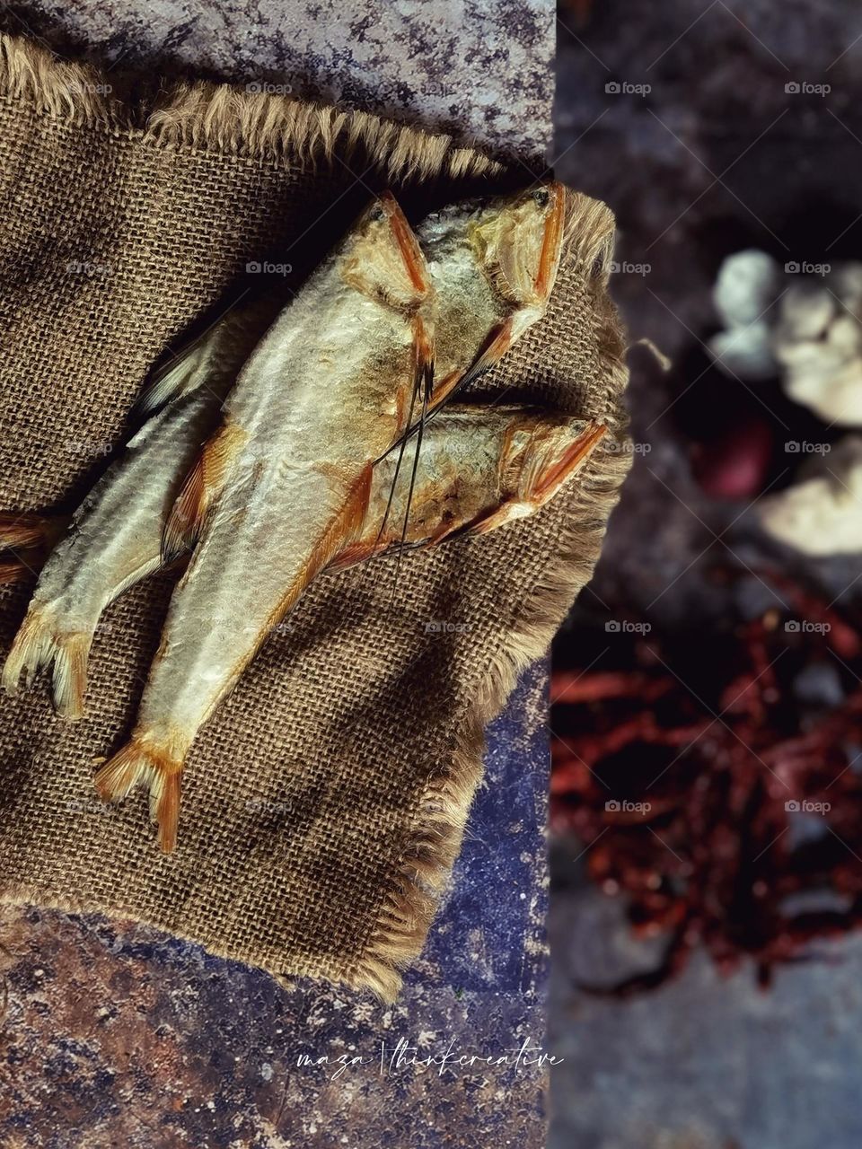 Salted dried fish on top of a table and other spices below