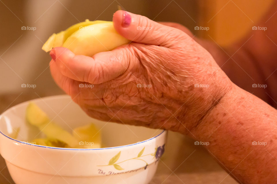 Woman's Aging Hands Peeling A Green Apple
