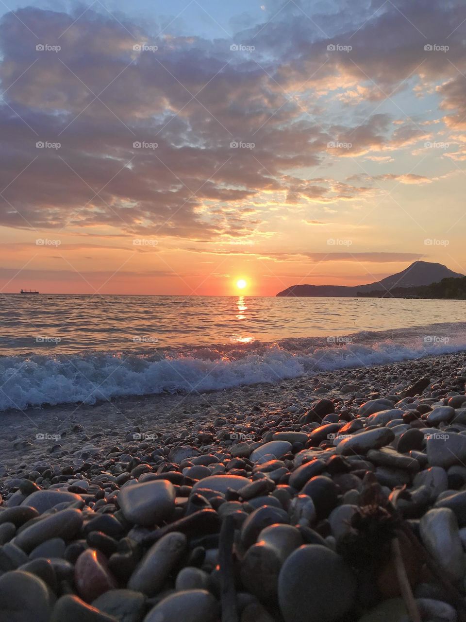 Sun is setting down at the rocky beach