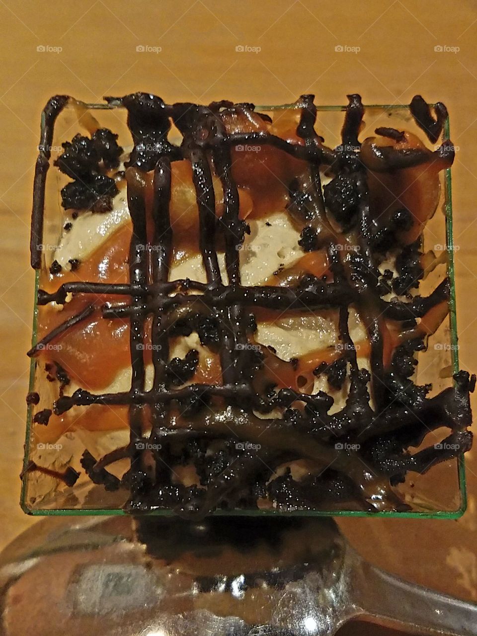 peanut butter and chocolate cream dessert topped with caramel and chocolate and a decorative design