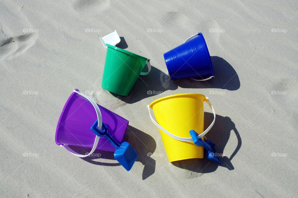 Beach buckets. A colorful collection of beach buckets on the sand