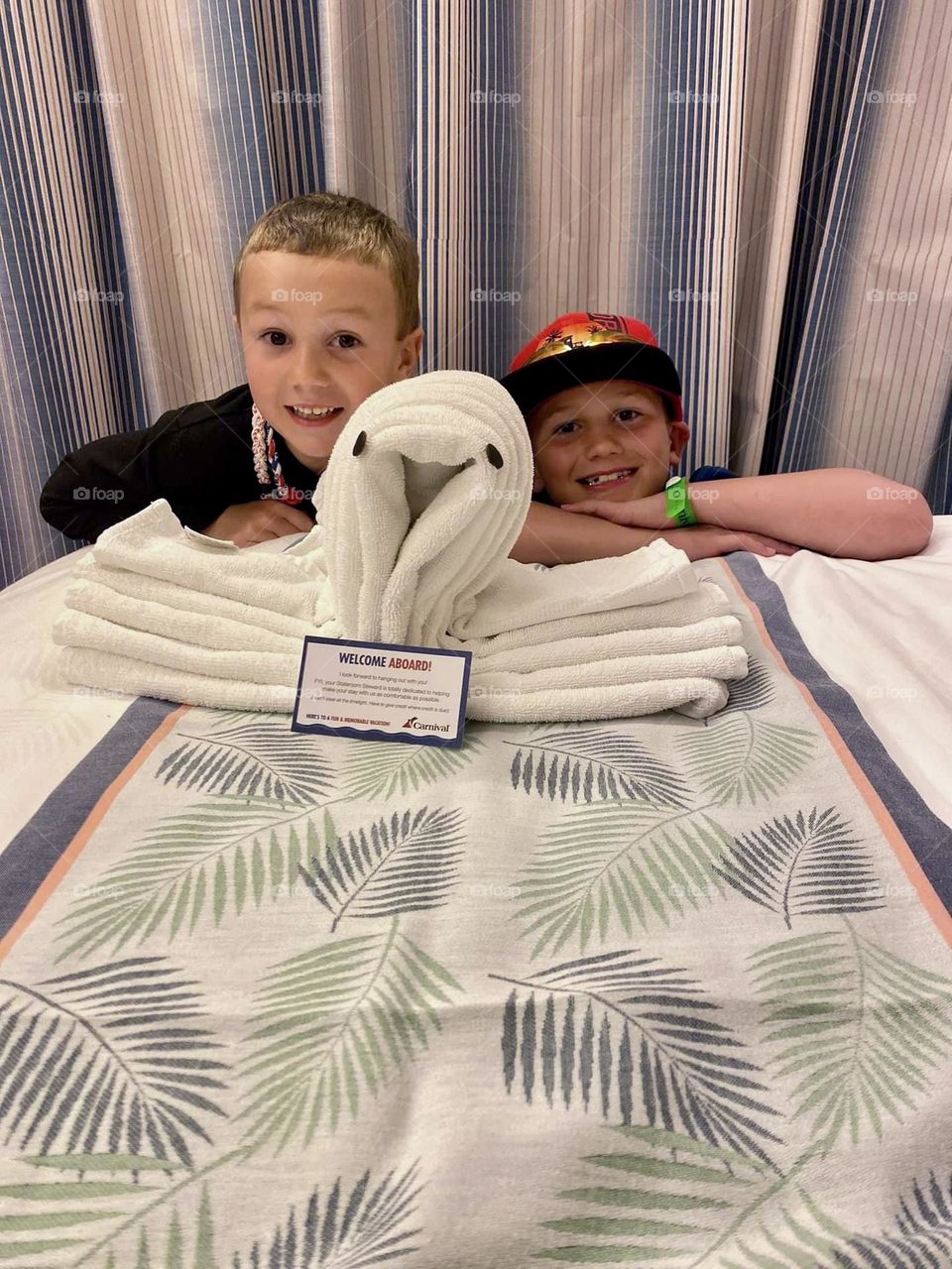 Two boys pose with an octopus made of towels on a cruise ship. Towel art is a fun way to be welcomed back to one’s room. 